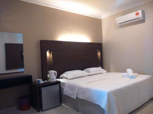 珍南海滩Ziella De Villa的卧室配有一张大白色床和电视。