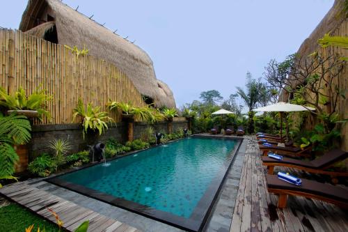 Bangli德科伦普巴厘生态旅游度假村的度假村的游泳池,配有椅子和遮阳伞