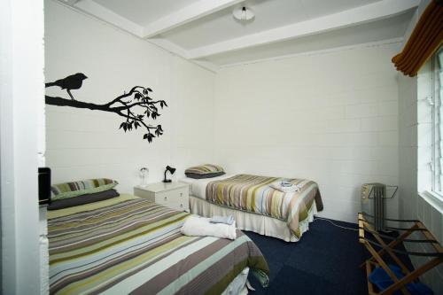 TinirotoMahaanui Quarters Farmstay的白色墙壁客房的两张床