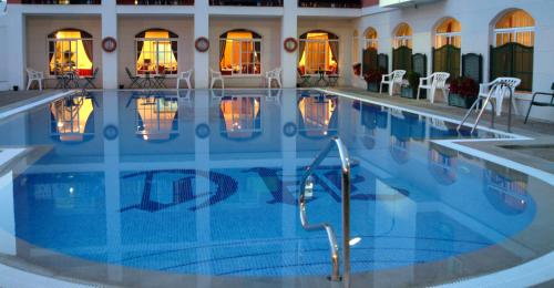 罗塔卡里布酒店的酒店的大型游泳池配有桌椅