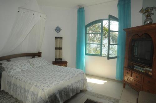 伊利亚贝拉Azur Guesthouse的一间卧室设有一张床、一台电视和一个窗口。