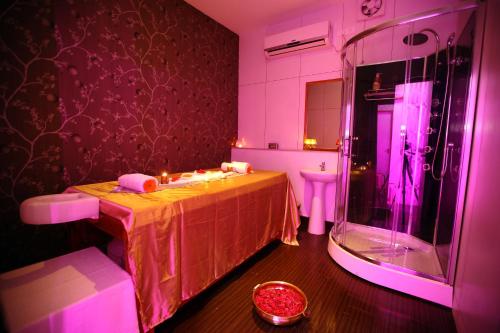 钦奈Raj Park Hotel Chennai的带淋浴、桌子和水槽的浴室