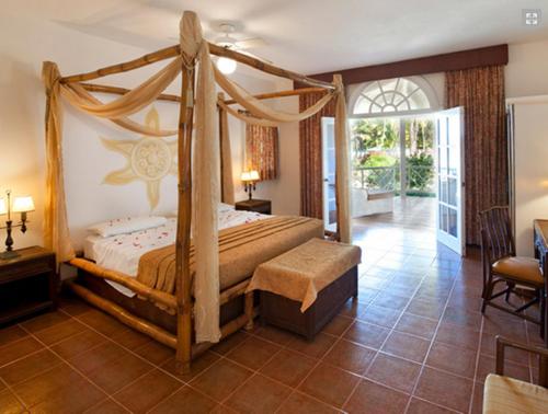 拉斯加勒拉斯塞雷纳别墅酒店的一间卧室设有天蓬床和庭院。