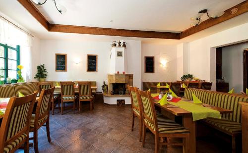 巴特尚道Kurparkstübl Bad Schandau的餐厅设有木桌、椅子和壁炉