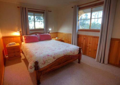 BallandeanAccommodation Creek Cottages & Sundown View Suites的一间卧室设有一张大床和两个窗户。