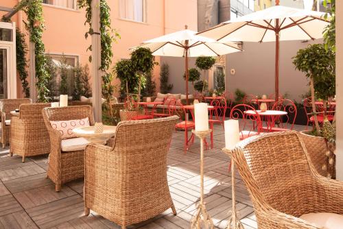 里斯本Maxime Hotel Lisbon的一个带桌椅和遮阳伞的户外庭院。