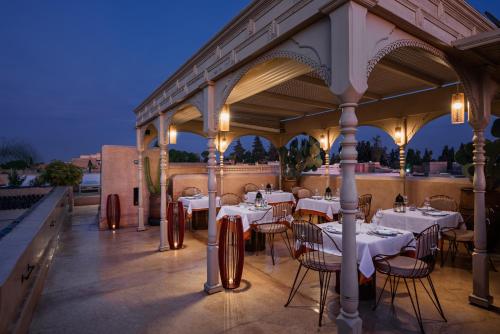 马拉喀什72 Riad的庭院里的餐厅配有白色的桌椅