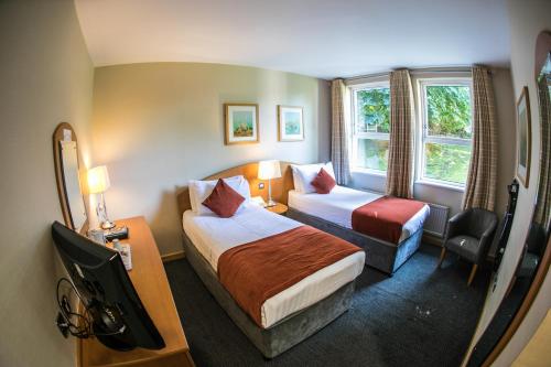 巴利米纳凯尔斯罗斯帕克酒店的一间酒店客房,设有两张床和电视