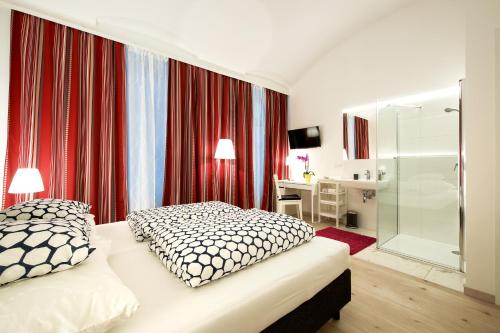 维也纳Pension am Wienfluss的一间卧室设有一张床和一个玻璃淋浴间