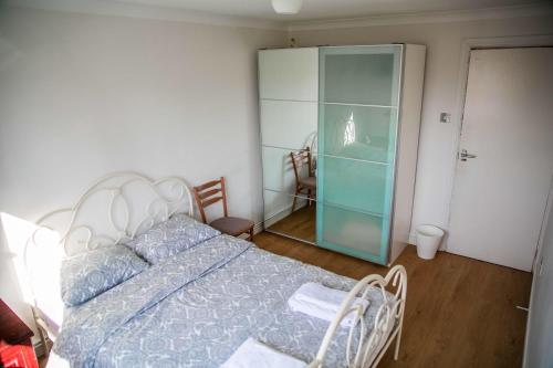 萨顿Double bedroom in ashared flat的一间卧室配有一张床和一个玻璃衣柜