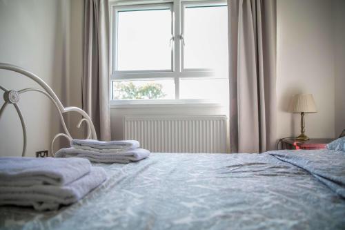 萨顿Double bedroom in ashared flat的一间卧室配有带毛巾的床