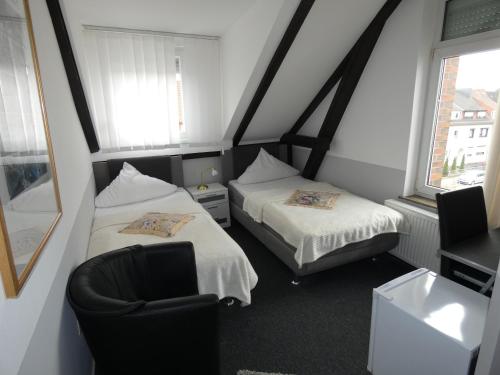 不莱梅沃特尔思酒店的小房间设有两张床和椅子
