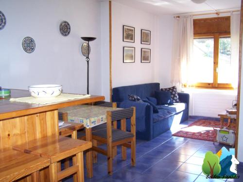 因克勒斯因克勒斯索尔德天堂公寓的客厅配有桌子和蓝色沙发