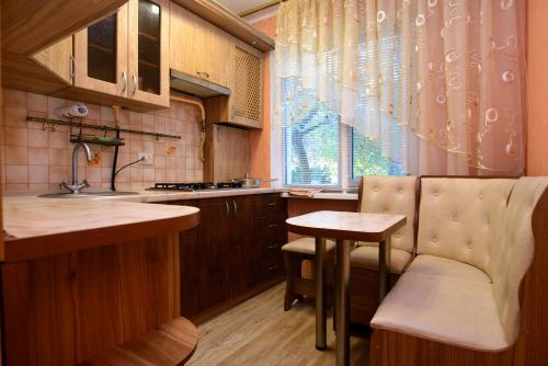 切尔卡瑟Апартаменты Deluxe的厨房配有水槽、桌子和窗户