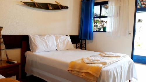 卡纳内亚Pousada Via Maria的卧室配有一张床,墙上有一条船