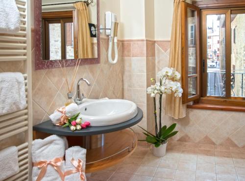 托尔贾诺Boutique Hotel al Grappolo d'Oro的一间带水槽和镜子的浴室