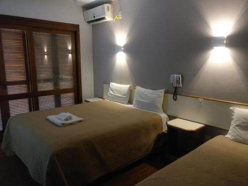 Sao Pedro do SulSítio Hotel e Eventos的酒店客房,配有两张带毛巾的床