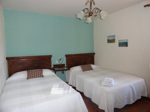 OrmáizteguiCasa Rural Etxaluze的蓝色墙壁客房的两张床