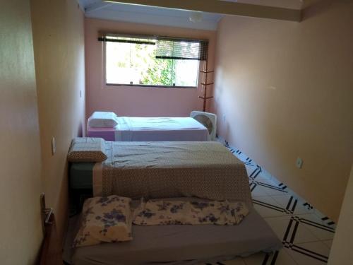 库穆鲁沙蒂巴Apartamento Cumuru的小房间设有两张床和窗户