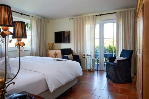 林道维里诺酒店的一间卧室配有一张大床和两把椅子