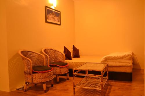 巴克塔普尔Pradhan House - Home Stay with Garden的一间卧室配有一张床、两把椅子和一张桌子