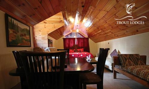 GhumlaTrout Lodges的一间带桌子的客厅和一间卧室