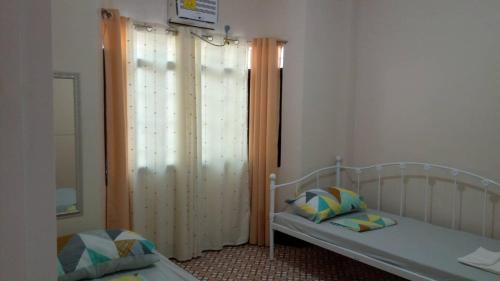 塔比拉兰JMC Residence的一间卧室设有两张床和大窗户