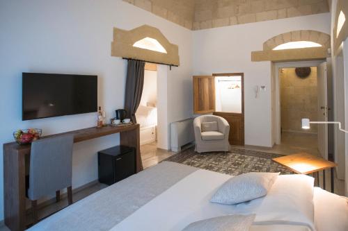 马泰拉Palazzo Montemurro的一间卧室配有一张床,墙上配有电视