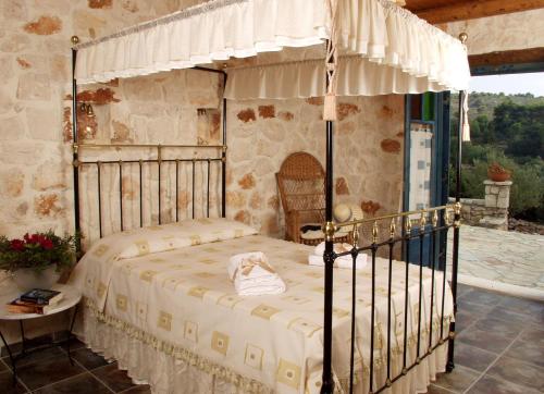 凯里翁雷沃拉传统石头别墅和公寓酒店的一间卧室配有一张带天蓬的床