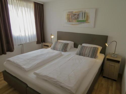 梅特拉赫萨尔布里克梅特拉赫酒店的卧室配有一张带两个枕头的大白色床