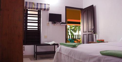 坎努尔Kannur Beach view Homestay的一间卧室配有一张床、一张书桌和一个窗户。