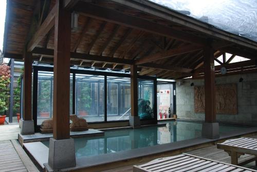 台北山乐温泉酒店的一座带玻璃窗的建筑中的游泳池