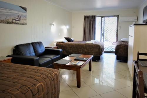 马库拉太平洋棕榈莫泰饭店的酒店客房带起居室,带一张床和一张沙发。