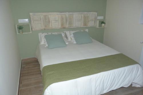 昆卡Casa de Tintas的卧室配有一张带两个枕头的大白色床