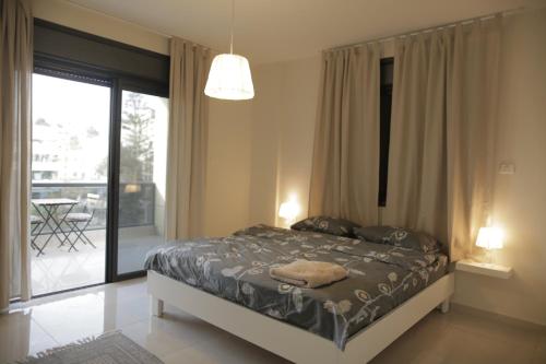 拉马拉Ramallah Modern Apartment的一间卧室设有一张床和一个滑动玻璃门