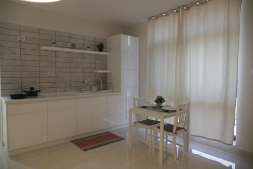 拉马拉Ramallah Modern Apartment的厨房配有桌子和两把椅子,设有窗户。