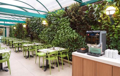 特拉维夫大都会酒店的一间带桌椅和绿色墙壁的餐厅