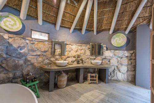 斯坦福Mosaic Lagoon Lodge的石质浴室设有两个水槽和石墙