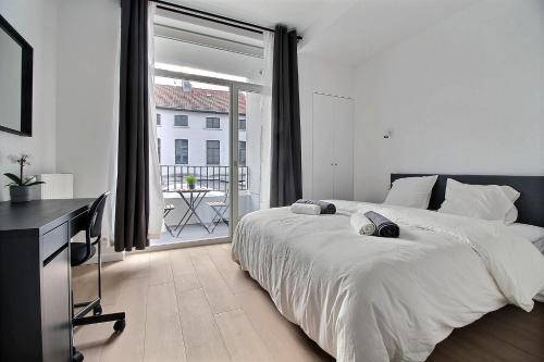 布鲁塞尔Rent a Flat - Bruxelles的一间卧室设有一张大床和一个大窗户