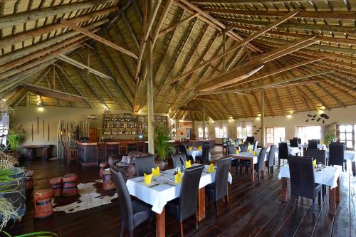 龙杜Gondwana Hakusembe River Lodge的大楼内带桌椅的用餐室