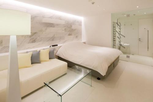 花卷市HOTEL LYISTA (Adult Only)的白色卧室配有床和沙发