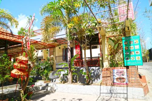 库塔Taste of Bali Hostel的一座棕榈树建筑