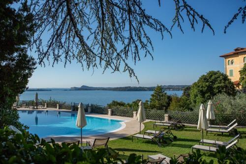 加尔多内-里维耶拉戴索诺别墅酒店的一个带遮阳伞的游泳池,享有水景