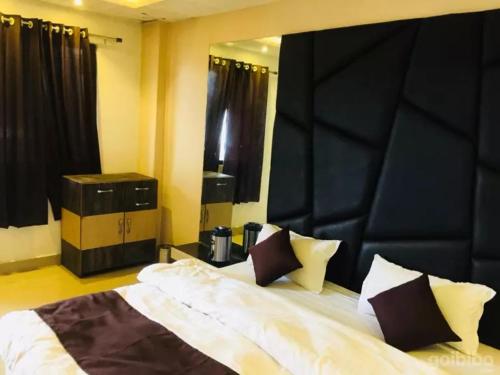 伯杰默里Hotel Khalsa -Lake View的一间卧室配有一张大床和黑色床头板