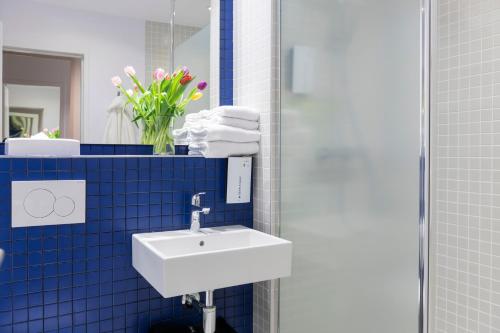 安特卫普安特卫普郁金香酒店的浴室设有白色水槽和蓝色瓷砖