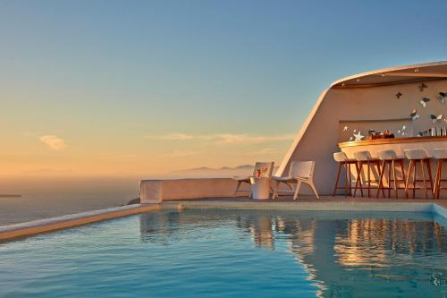 易莫洛林阿斯特拉套房酒店的毗邻大海的带桌椅的游泳池