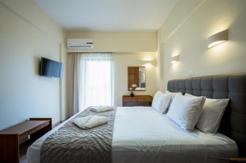 基萨莫斯格拉姆沃萨湾公寓式酒店的酒店客房配有一张带白色枕头的大床