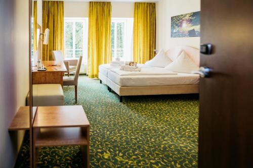 巴德马斯考福斯特普科勒公园库尔图尔酒店的配有一张床和一张书桌的酒店客房