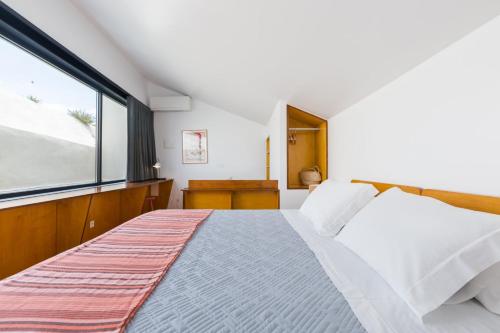 里斯本Patio São Vicente的一间卧室设有一张床和一个大窗户