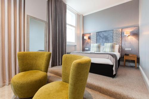 阿伯丁阿伯丁道格拉斯酒店的酒店客房,配有一张床和两把椅子